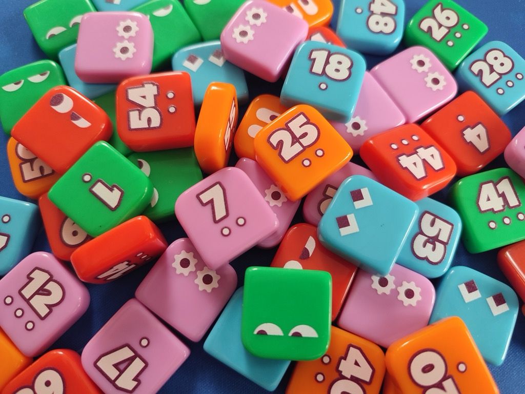 Chaque tuile porte un des 60 numéros du jeu avec sous le nombre de 1 à 3 petits  points.
